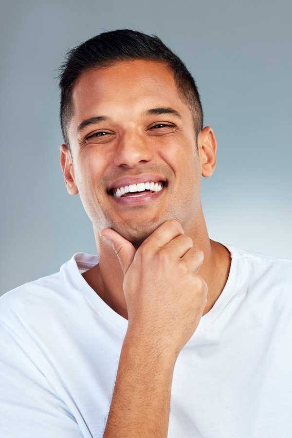 Man, portrait and smile with teeth in fresh or clean hygiene against a grey studio background. Happy male smiling for healthy lifestyle in satisfaction for dental, mouth and oral or gum care.